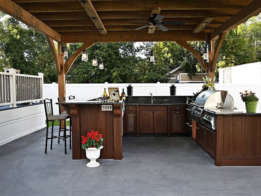Outdoor kitchen with raised bar and louver walnut cabinetry by Blue Mountain Design Bend Oregon